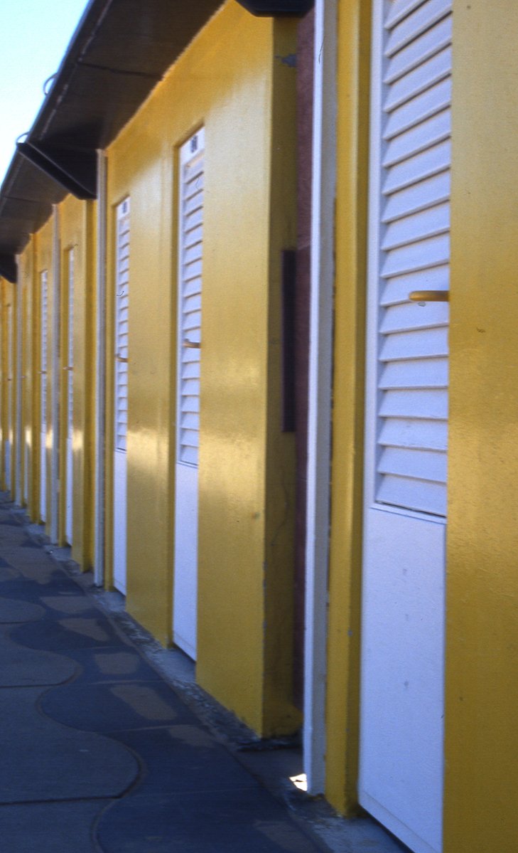 a row of yellow and white buildings with one door open