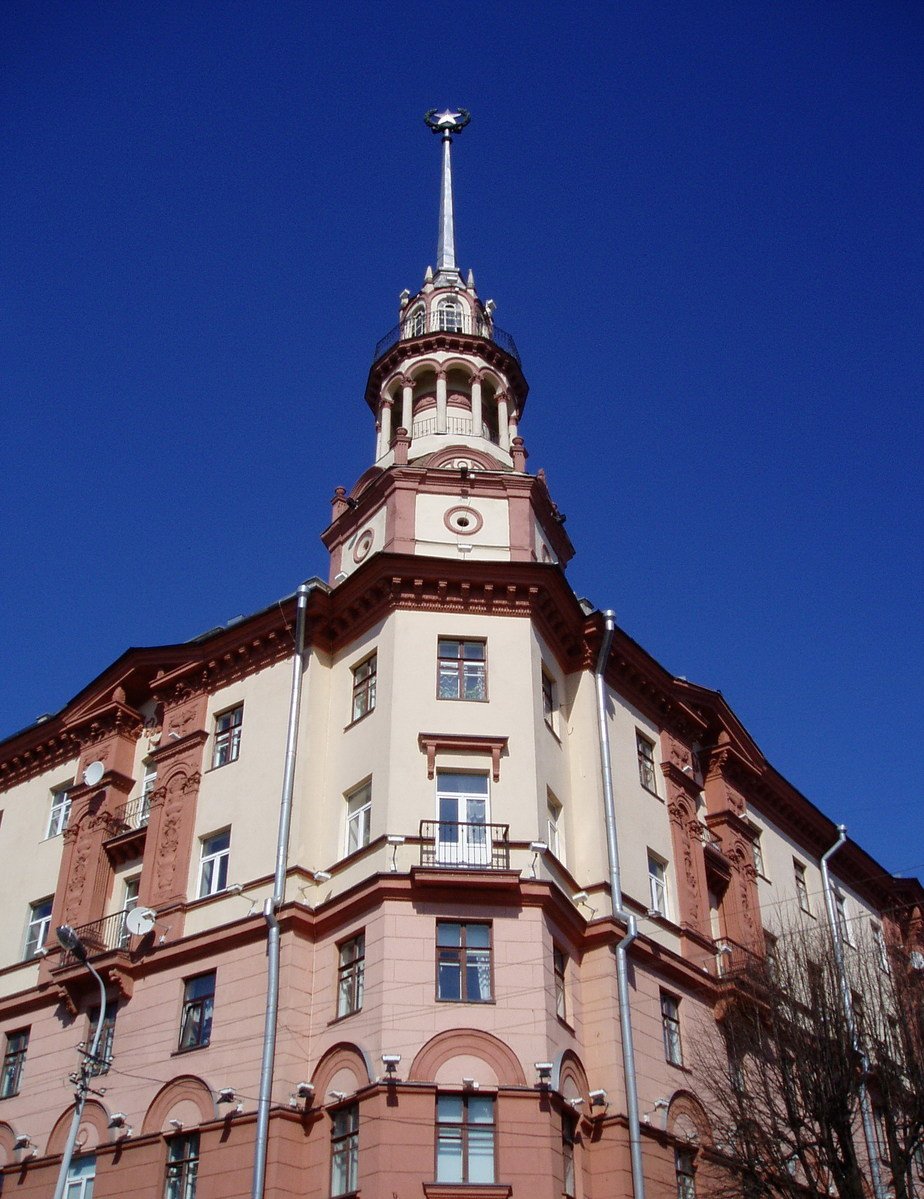 an orange building with a clock tower sitting in front of a blue sky