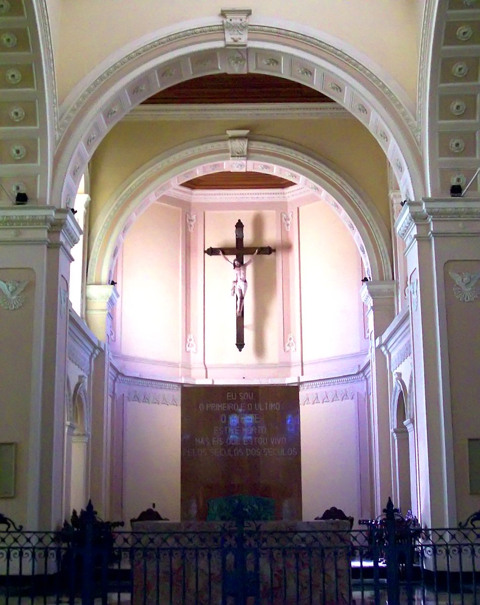 the interior of a cathedral, showing a wooden cross on the alter