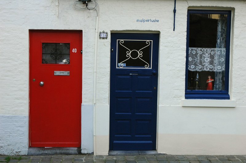 two red doors on a white building in england