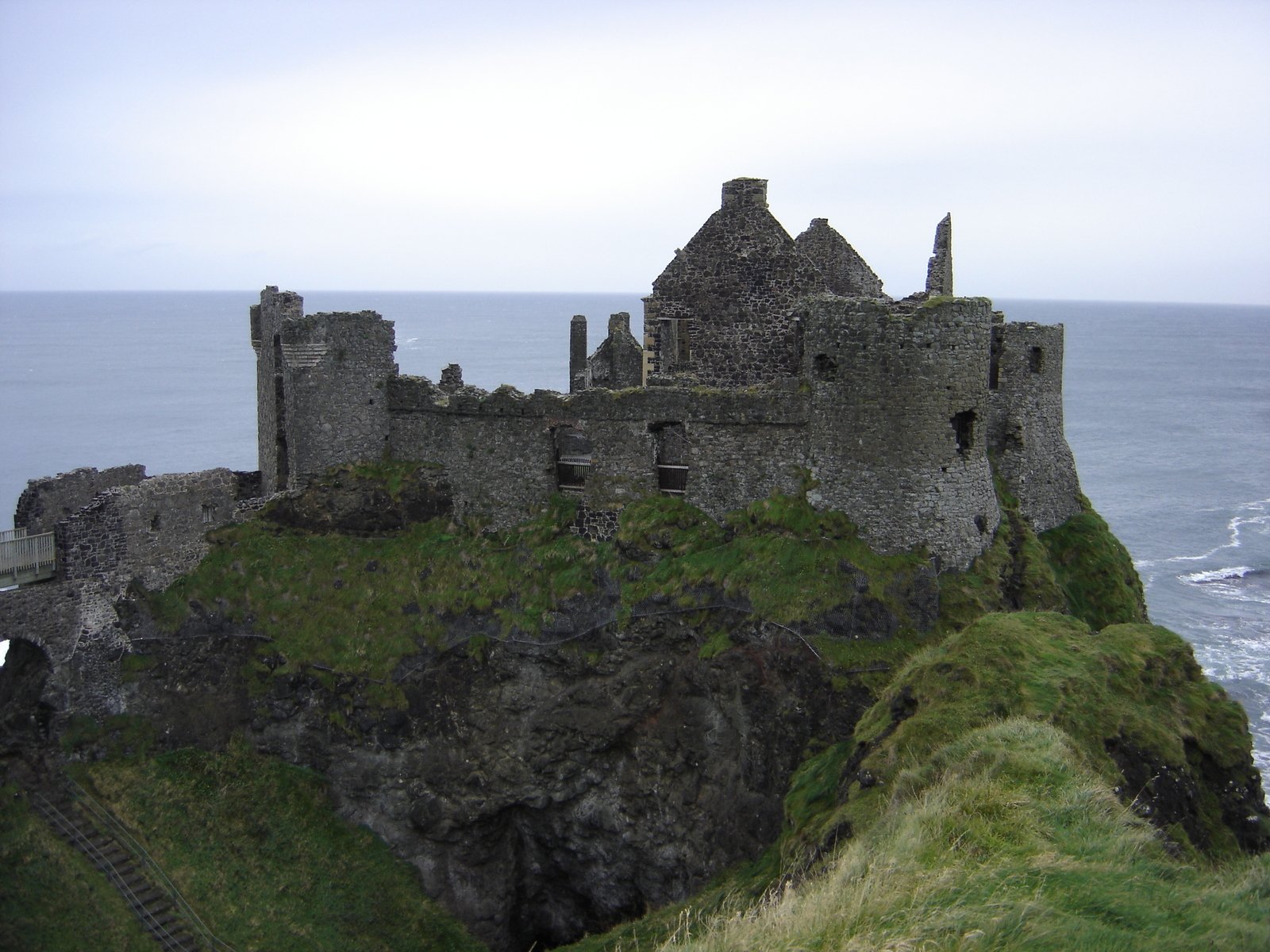 an old castle is sitting on the cliff edge near the ocean