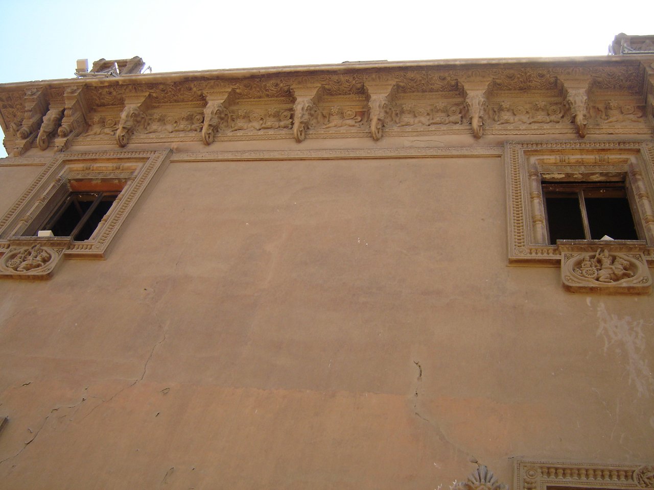 a beige building has three windows on each side