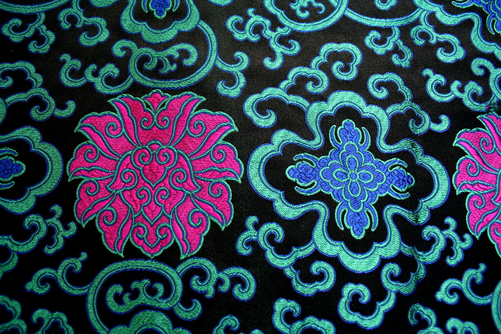 multicolored ornate design with blue and pink on black fabric
