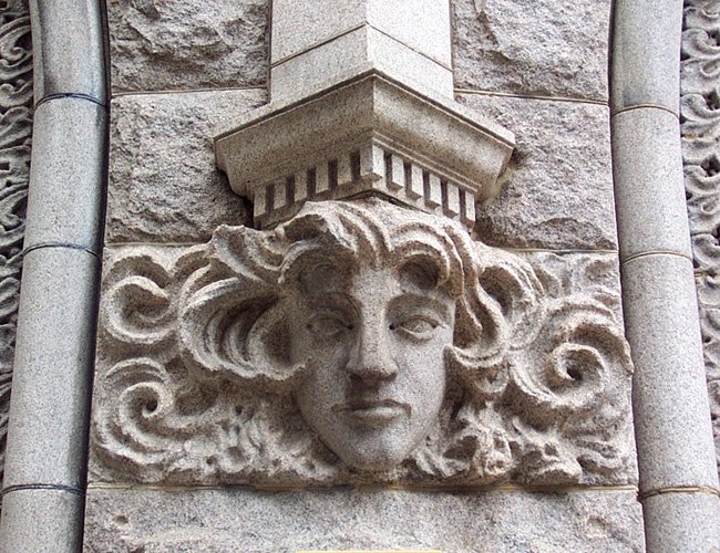 decorative statue depicting a face on a large stone building