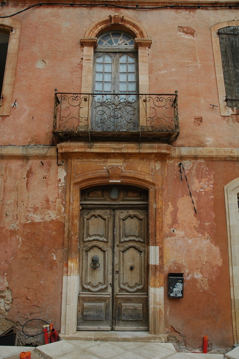 a very old building with a door and balcony