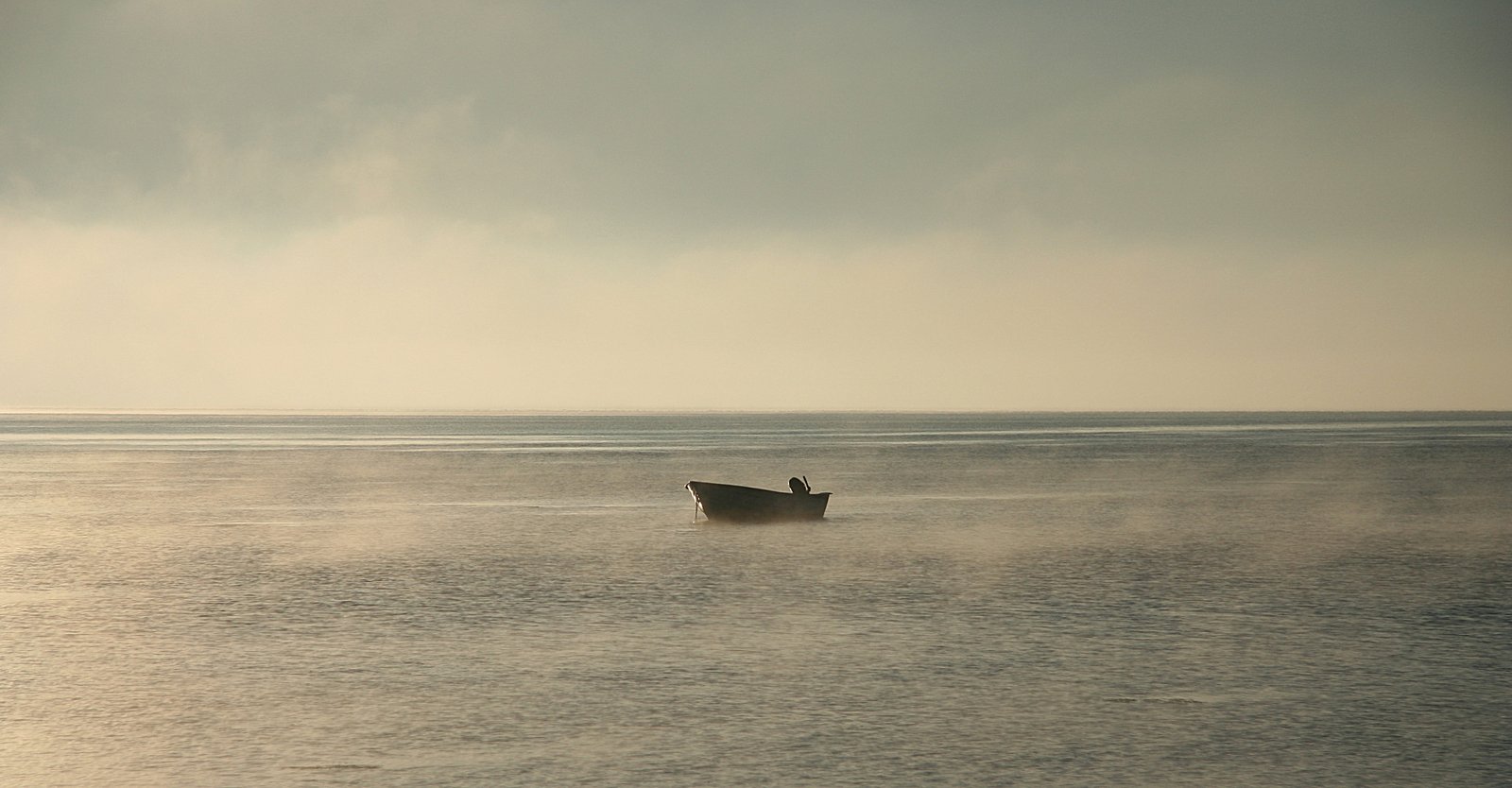 a boat is out on the water in the fog