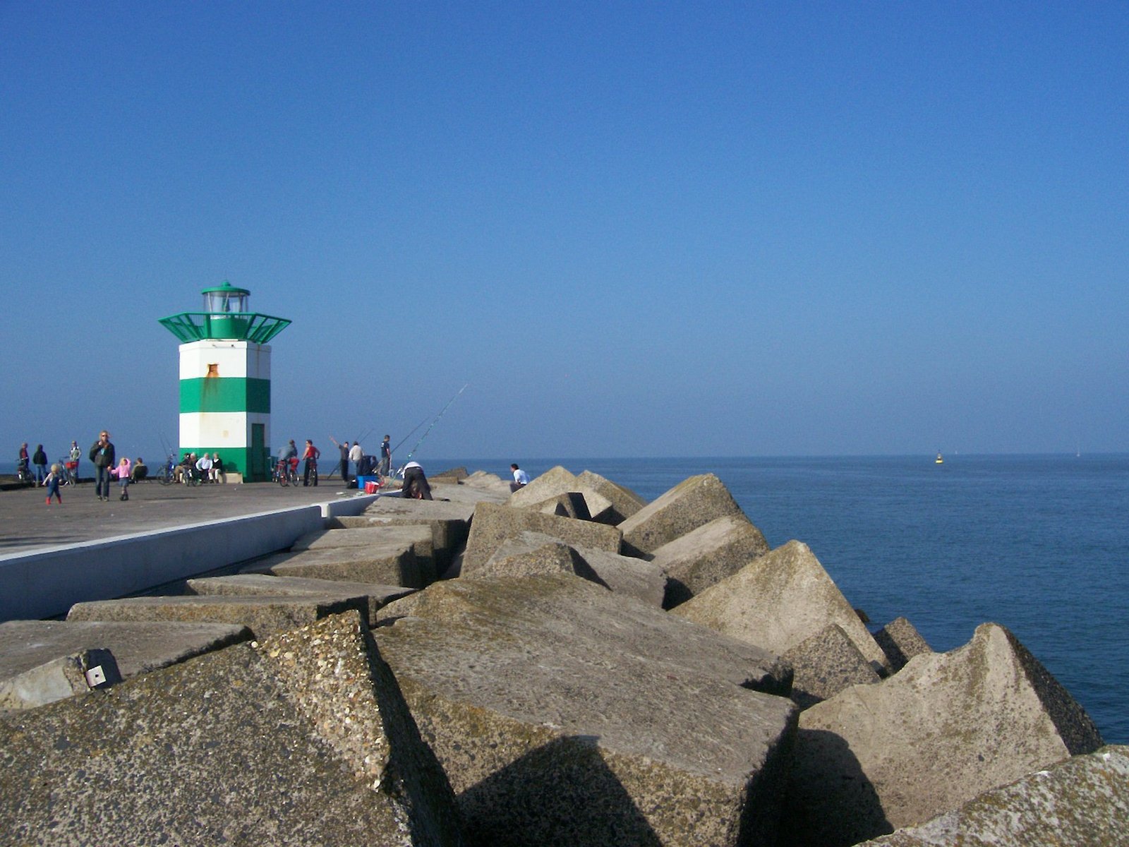 the sea wall has two green and white towers on top