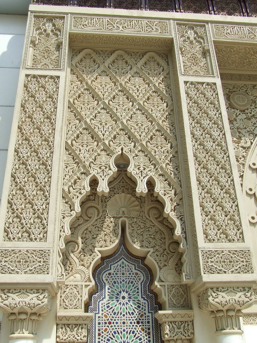 an intricate carved window with a clock in the middle