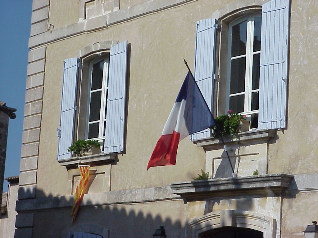 three flags are waving next to a building