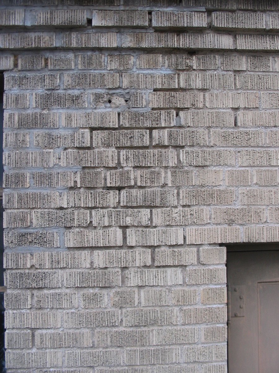 a clock is placed on a brick wall next to a doorway