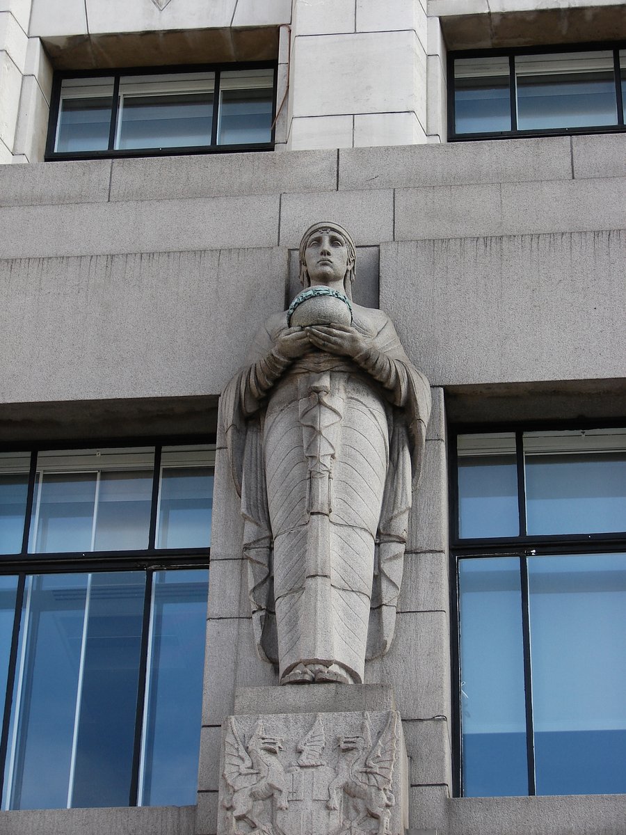 a tall building with an old statue on the top
