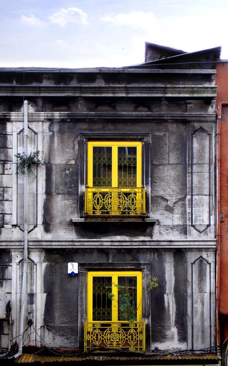 a tall building with yellow shutters and windows