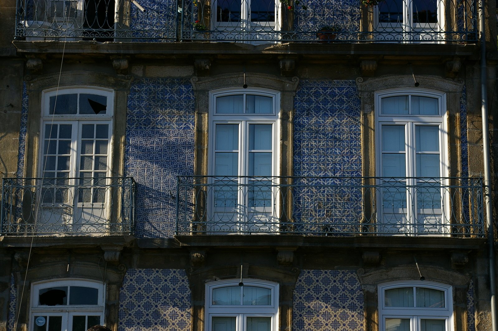 a woman sitting on a balcony in front of an ornate building