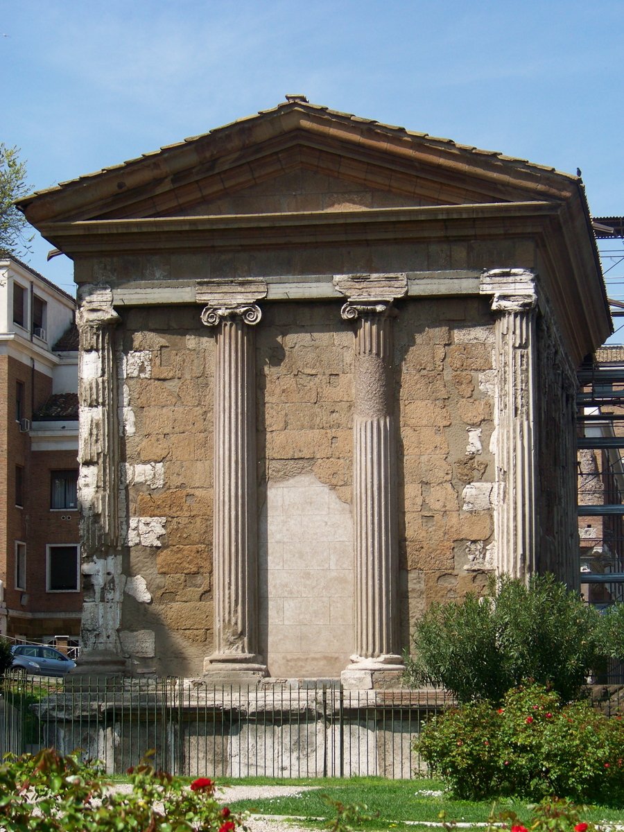 a building with three columns sitting outside of it