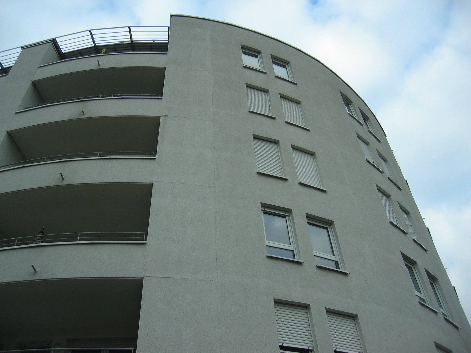 a tall building has several balconies and lots of windows