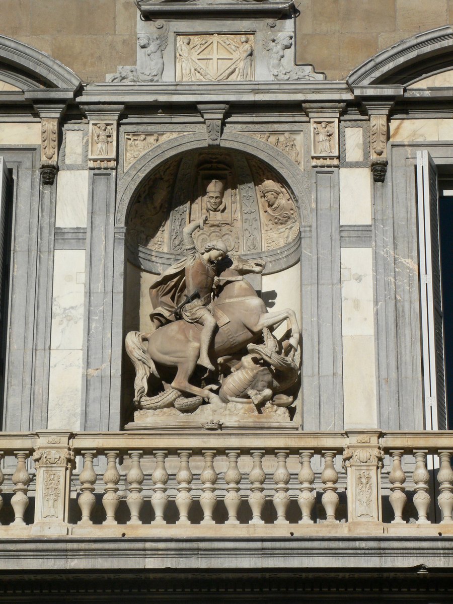 a statue of two men holding swords on top of a building