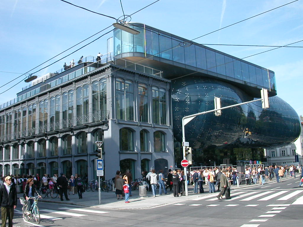 a large glass building that has people walking around