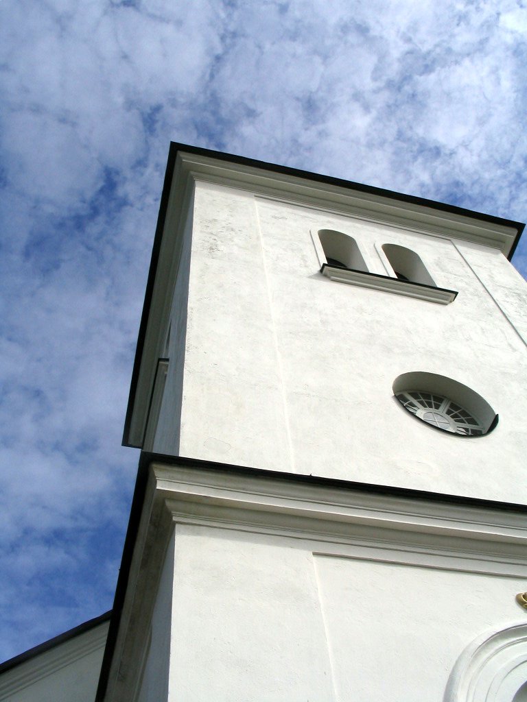 a white tower with three windows under the blue sky