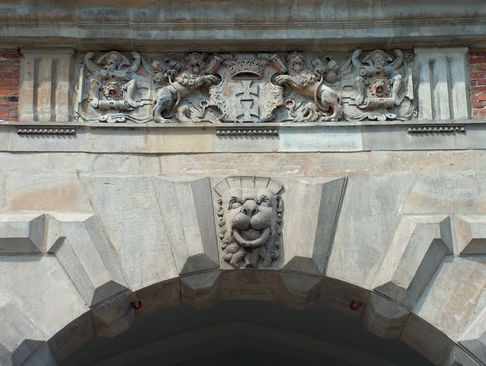 an arch with a lion's head and other carvings on it