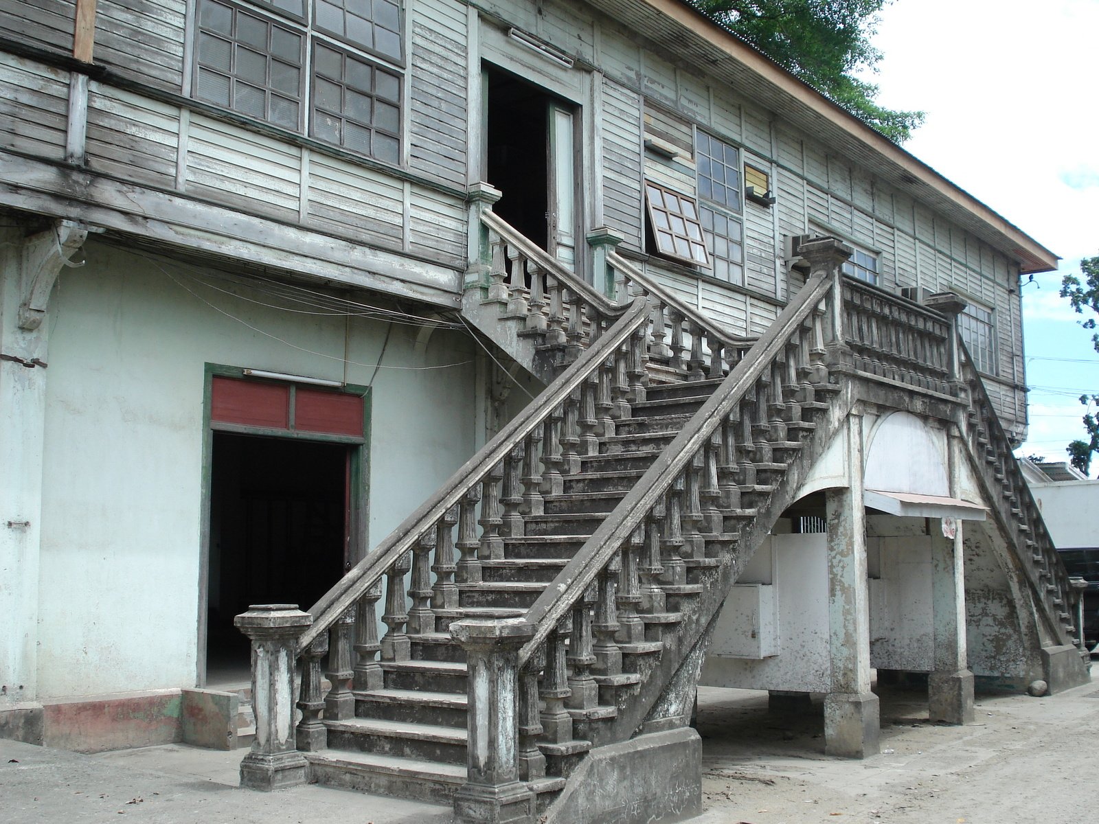 an old house with a wooden staircase leading to the door