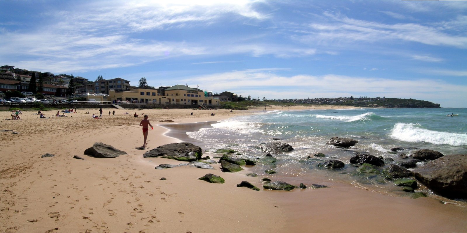 a person walking on the beach near the water