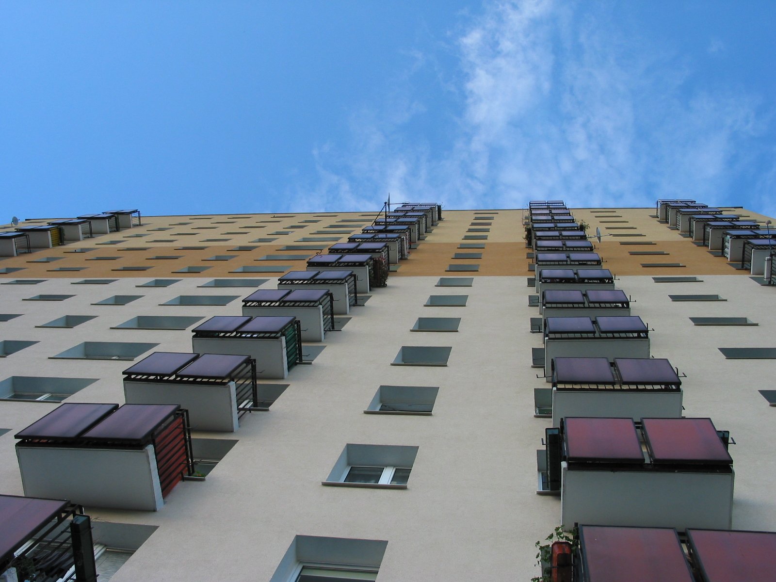 a tall building is filled with windows and red shutters