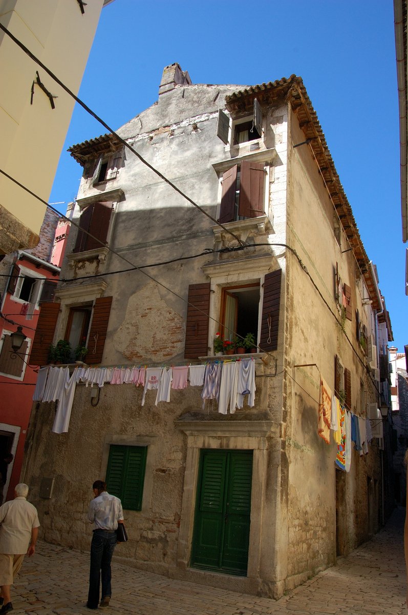 people walking on a street in front of old building