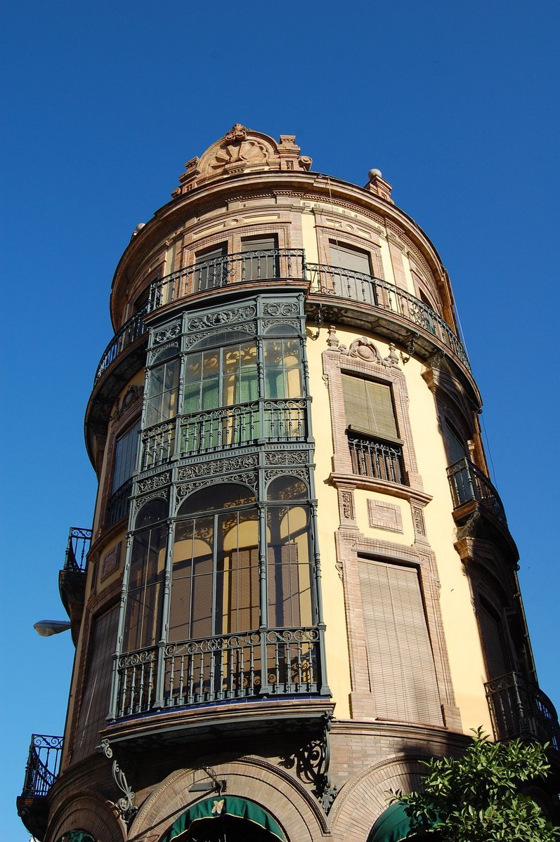 a tall building with several balconies, on a sunny day