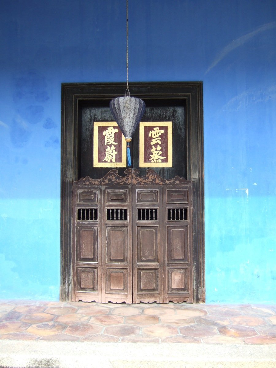 a double wooden door and one with a hanging fan over it