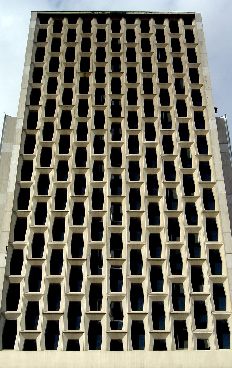 a high building with several square openings on it