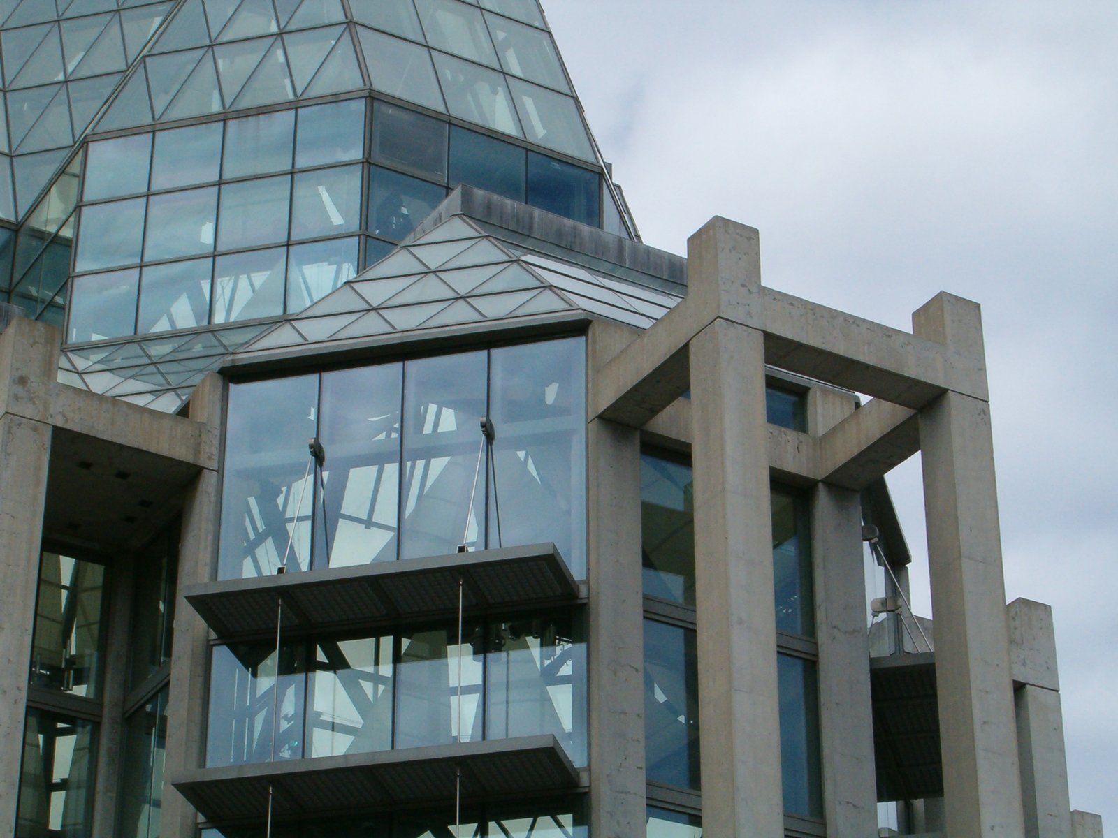 the corner of a modern building that looks like a glasshouse