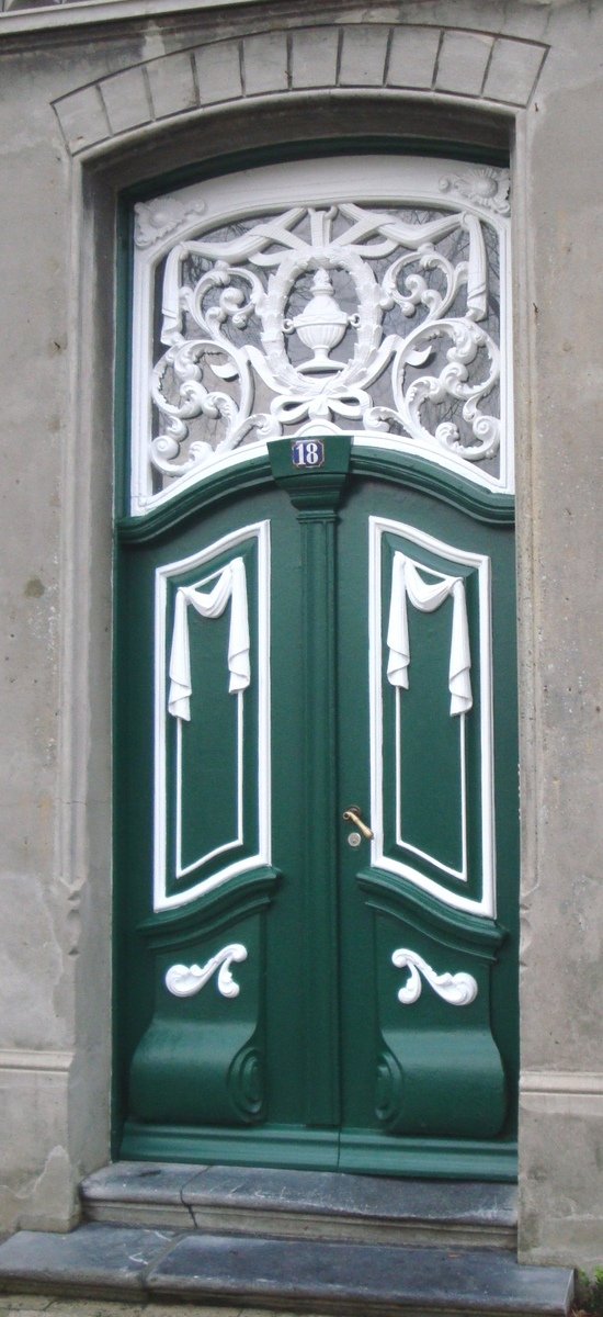 a green door with decorative design is shown