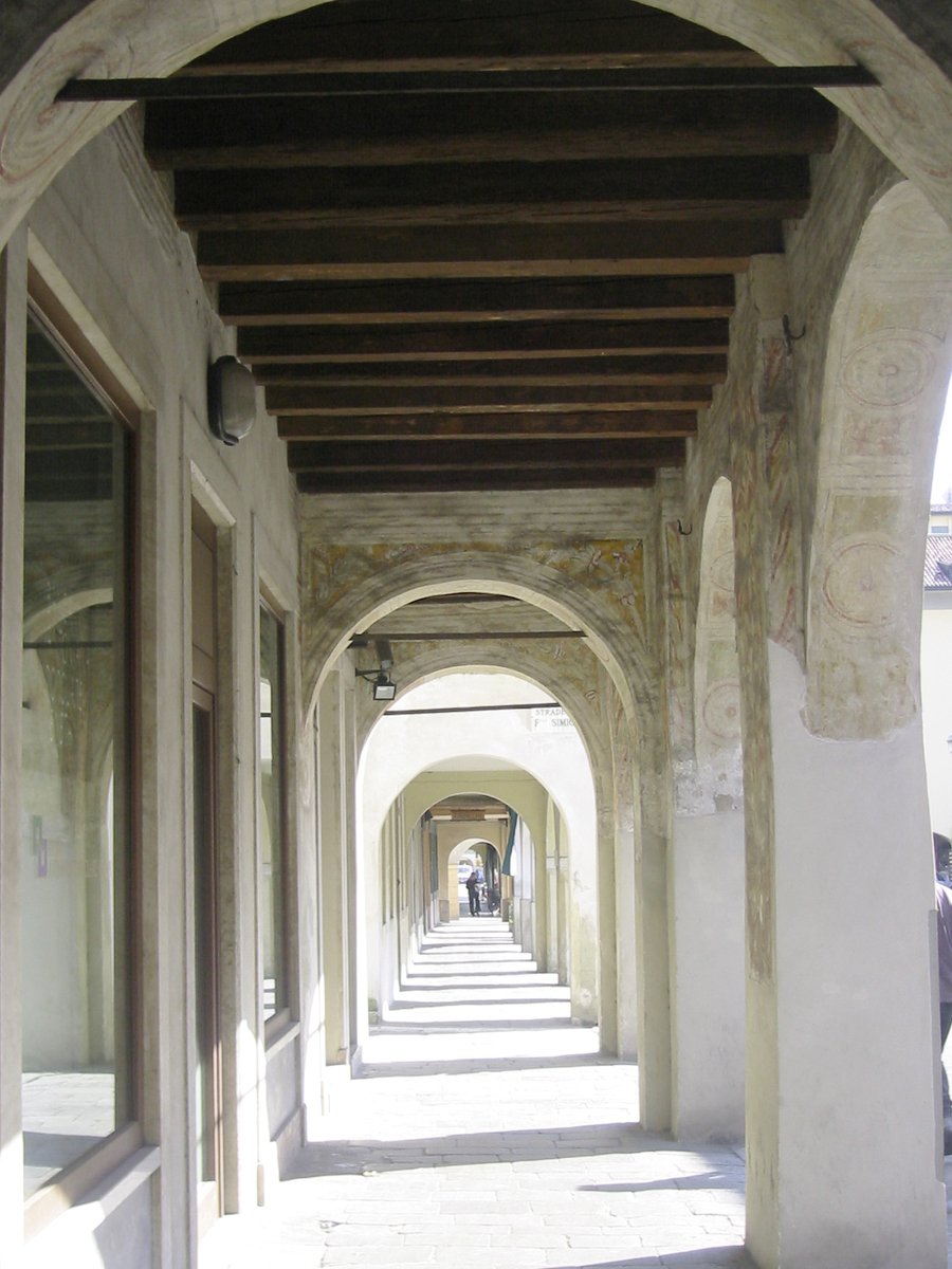 a long hallway with pillars and tile flooring