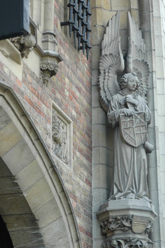 an angel statue near the wall of a building