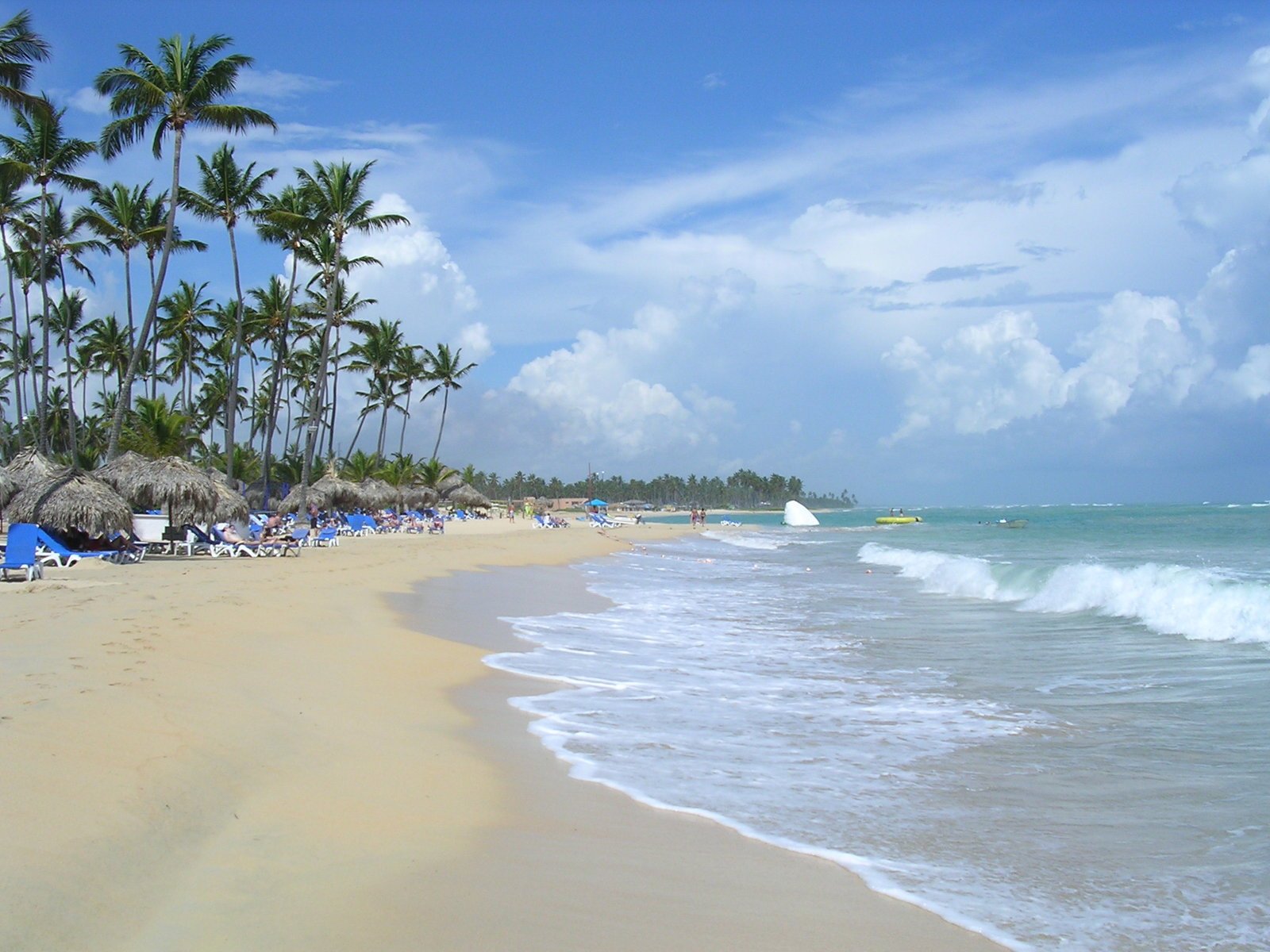 the sandy beach at tropical resort has blue umbrellas