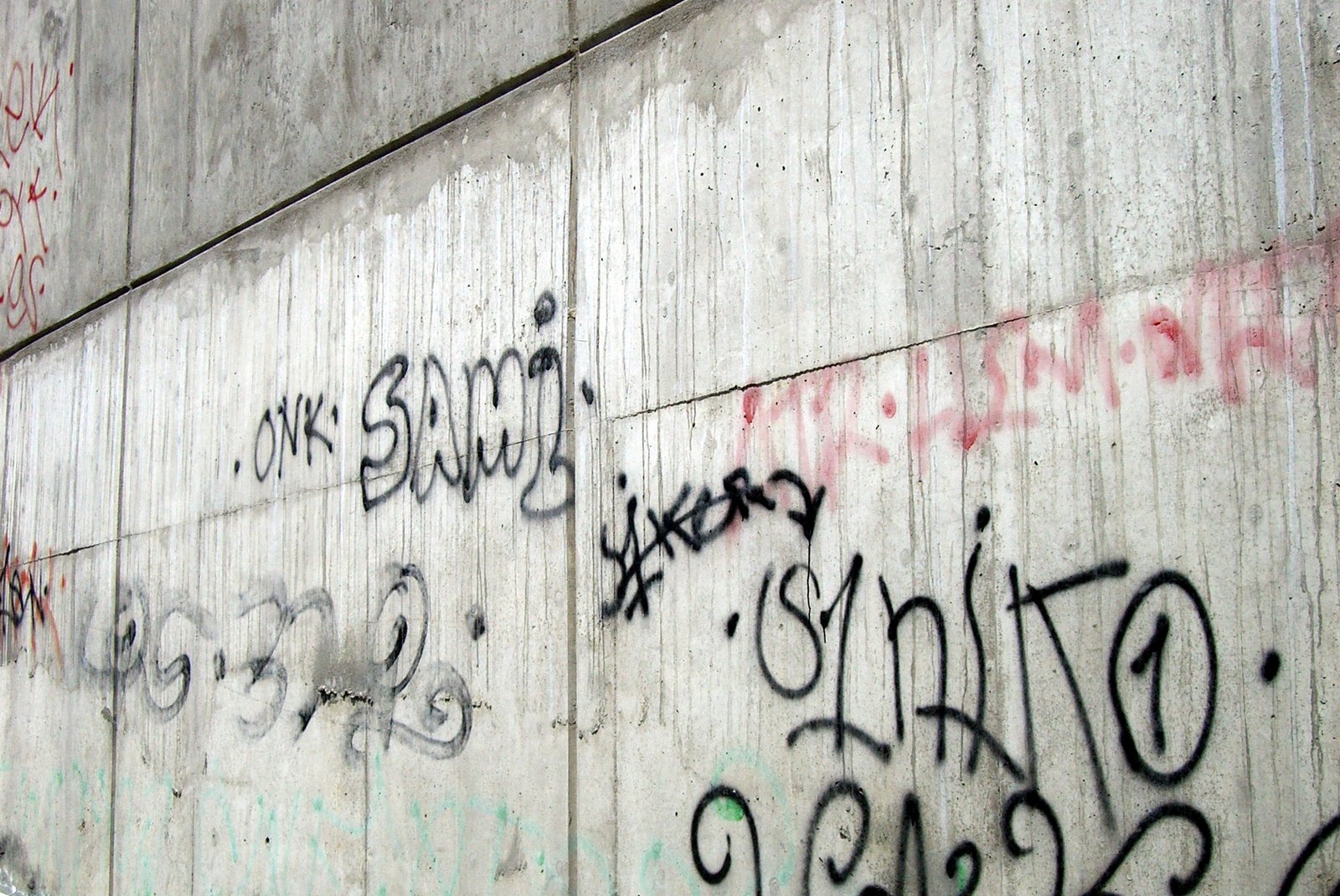 a wall is covered with various graffiti written on it