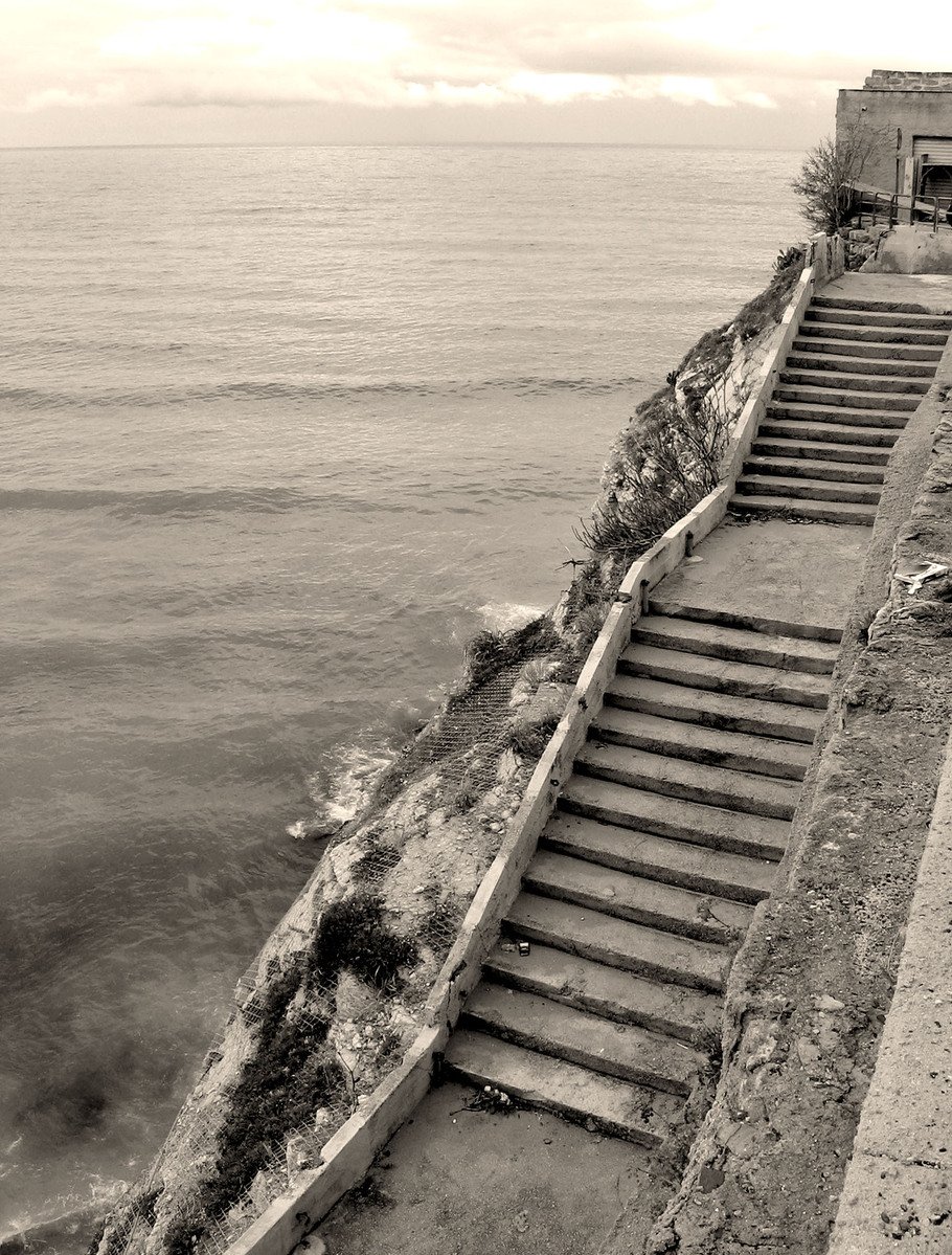 black and white pograph of steps leading to ocean