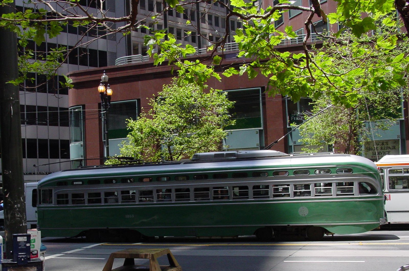 a bus is going down the street near some trees