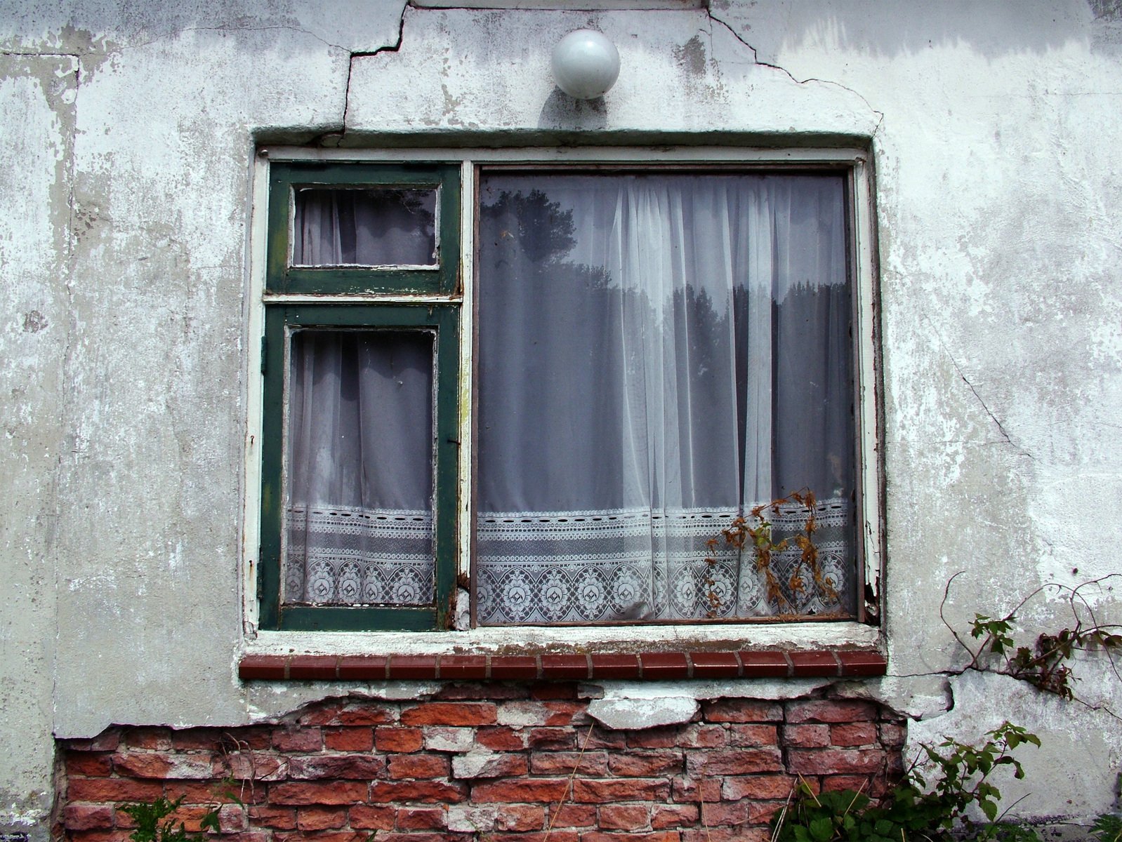 window with curtain and white blinds on building