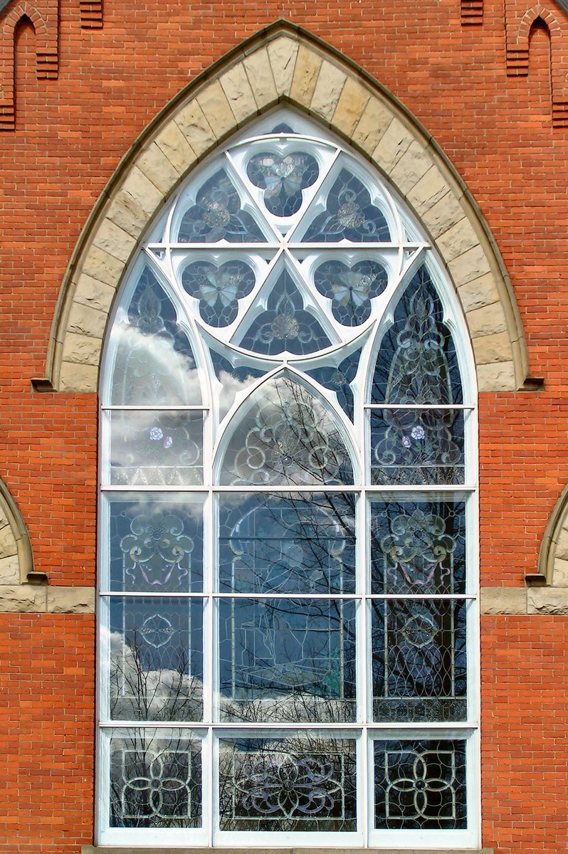 the reflection of a stained glass window in an arched window