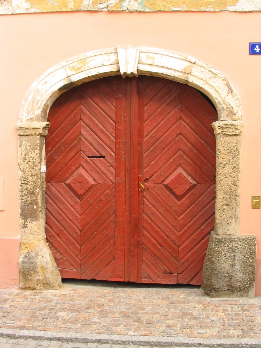 an old door is open near a brick wall
