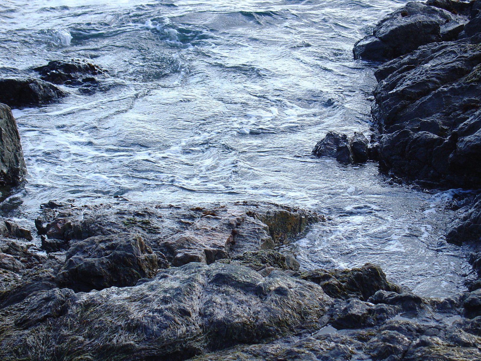 sea water is rushing through a rocky terrain