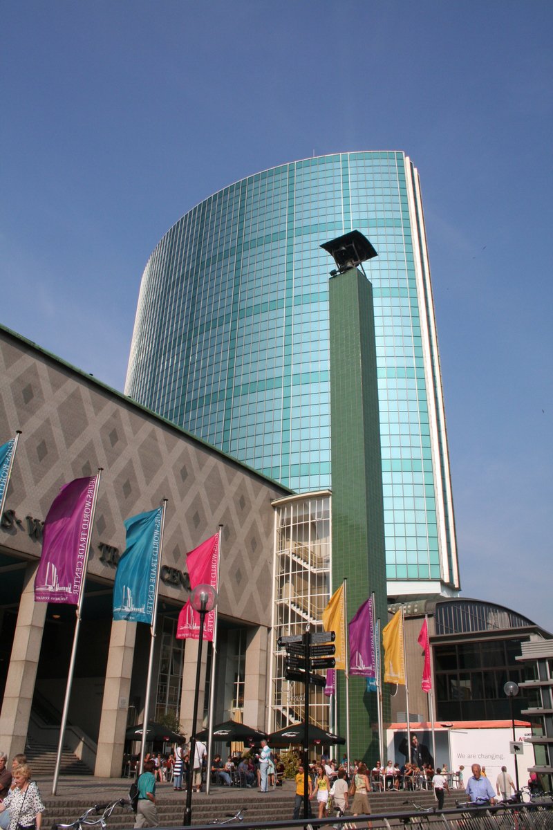 a tall building has colorful flags near it