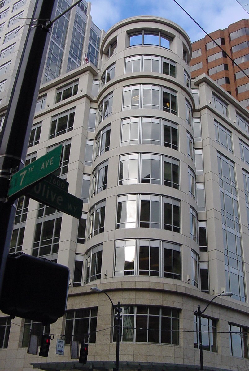 a corner street corner with the corner of an office building and another street sign