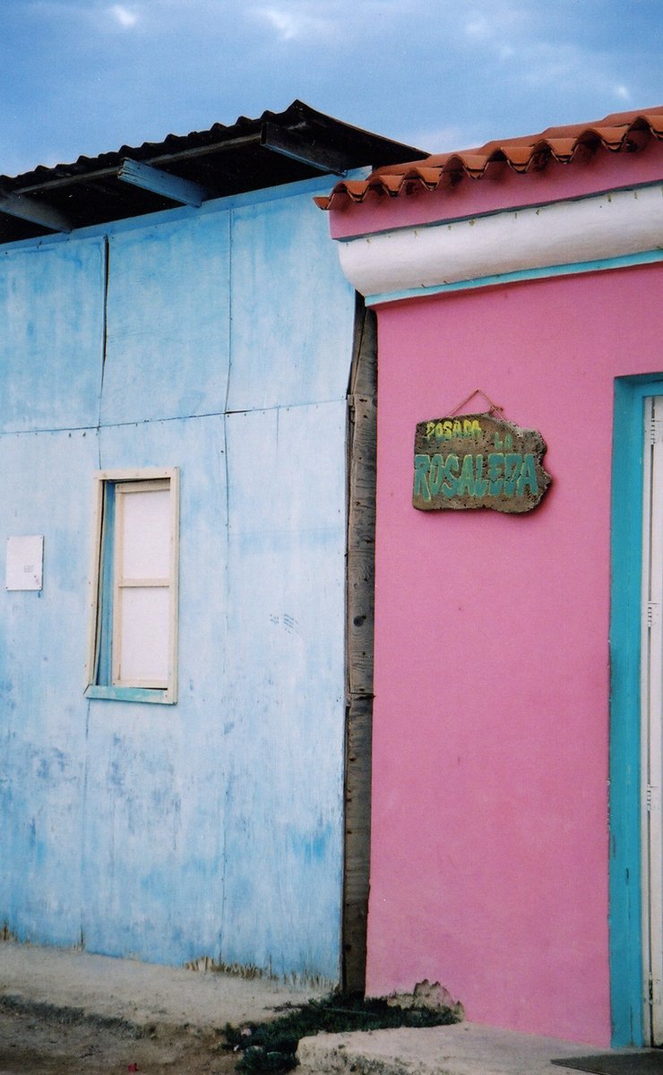 a pink building sitting next to a blue building