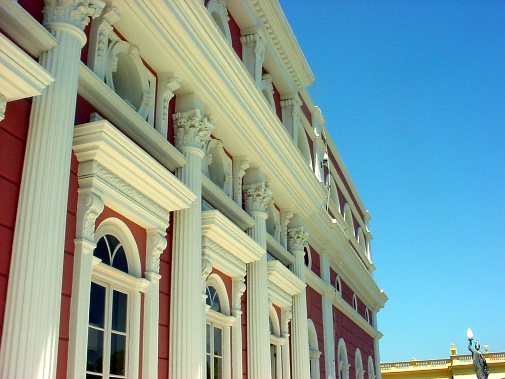 white columns are on the side of a pink and white building