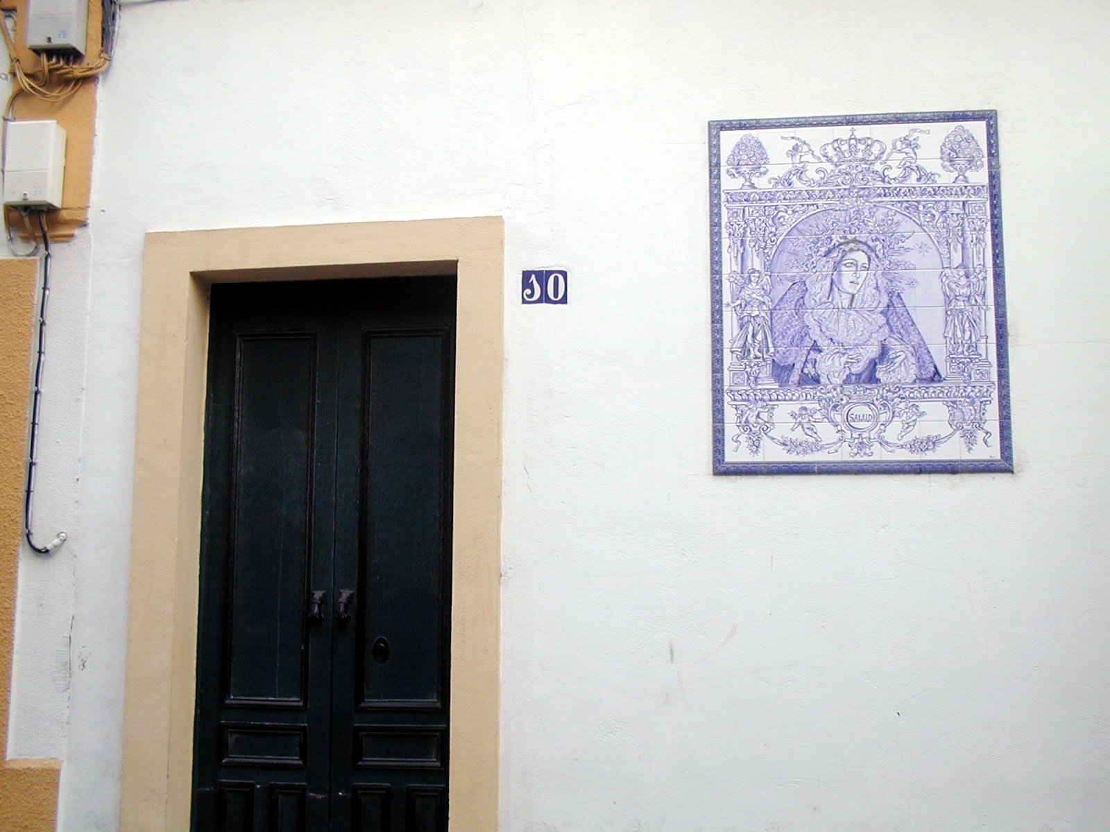 an entrance with an open door and a painting hanging above