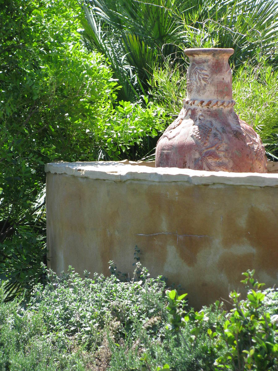 a large vase sitting inside of a stone garden pit