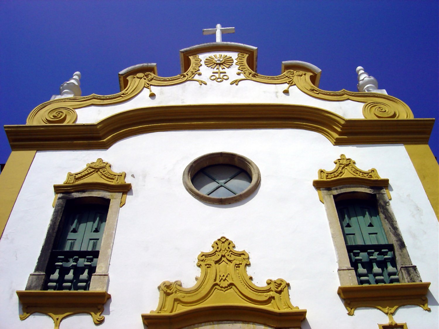 a white building with windows and a cross on the top