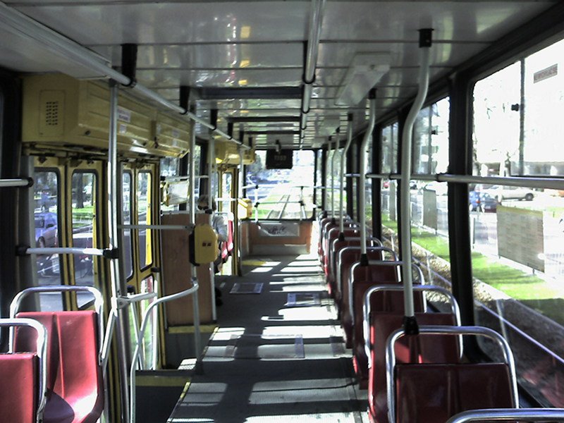 a empty bus has many seats on both sides of the empty bus